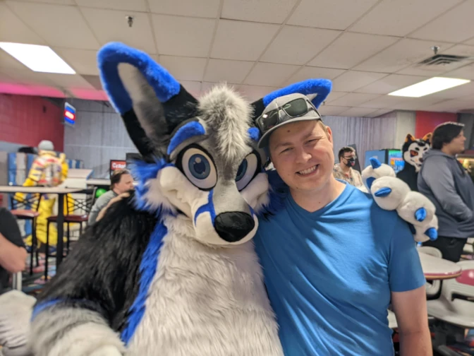 Me, standing next to a person in a wolf fursuit at a bowling alley